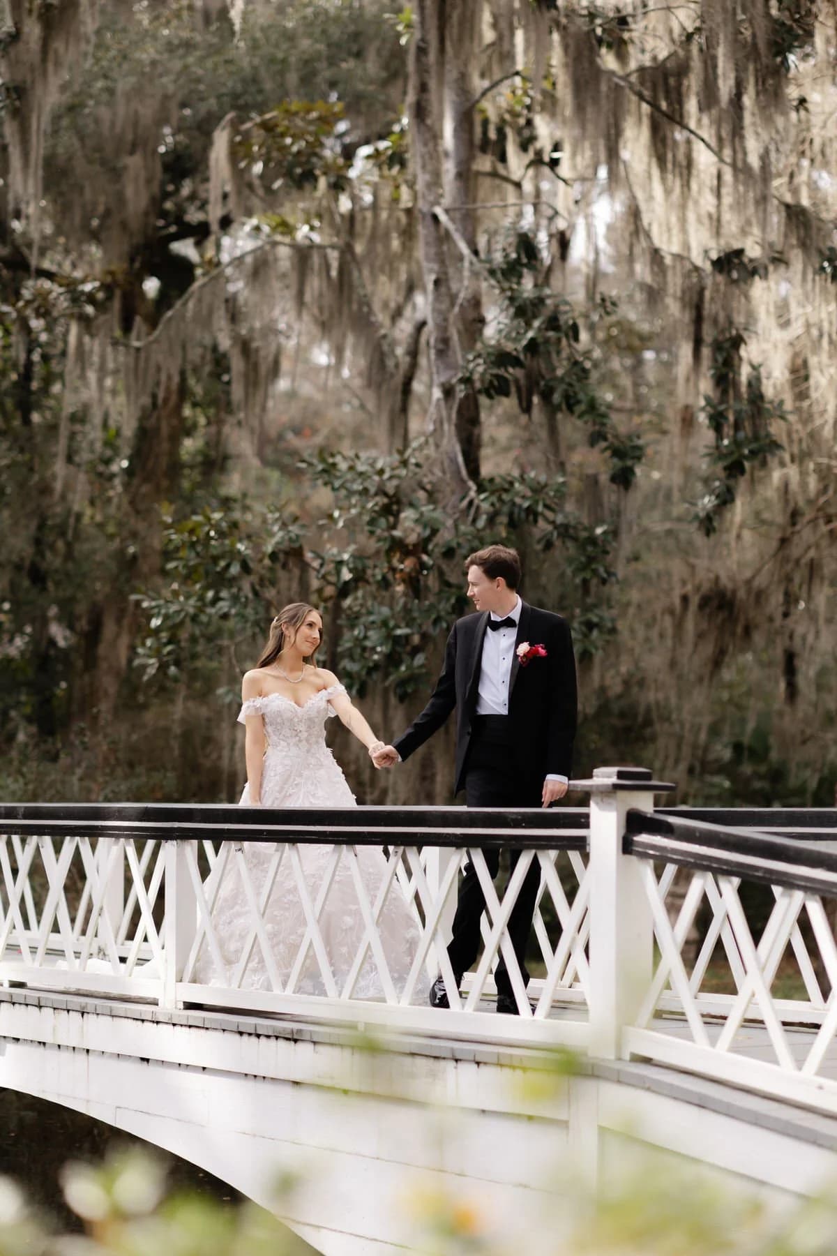 Bride and groom on white bridge at Magnolia Plantation wedding in Charleston